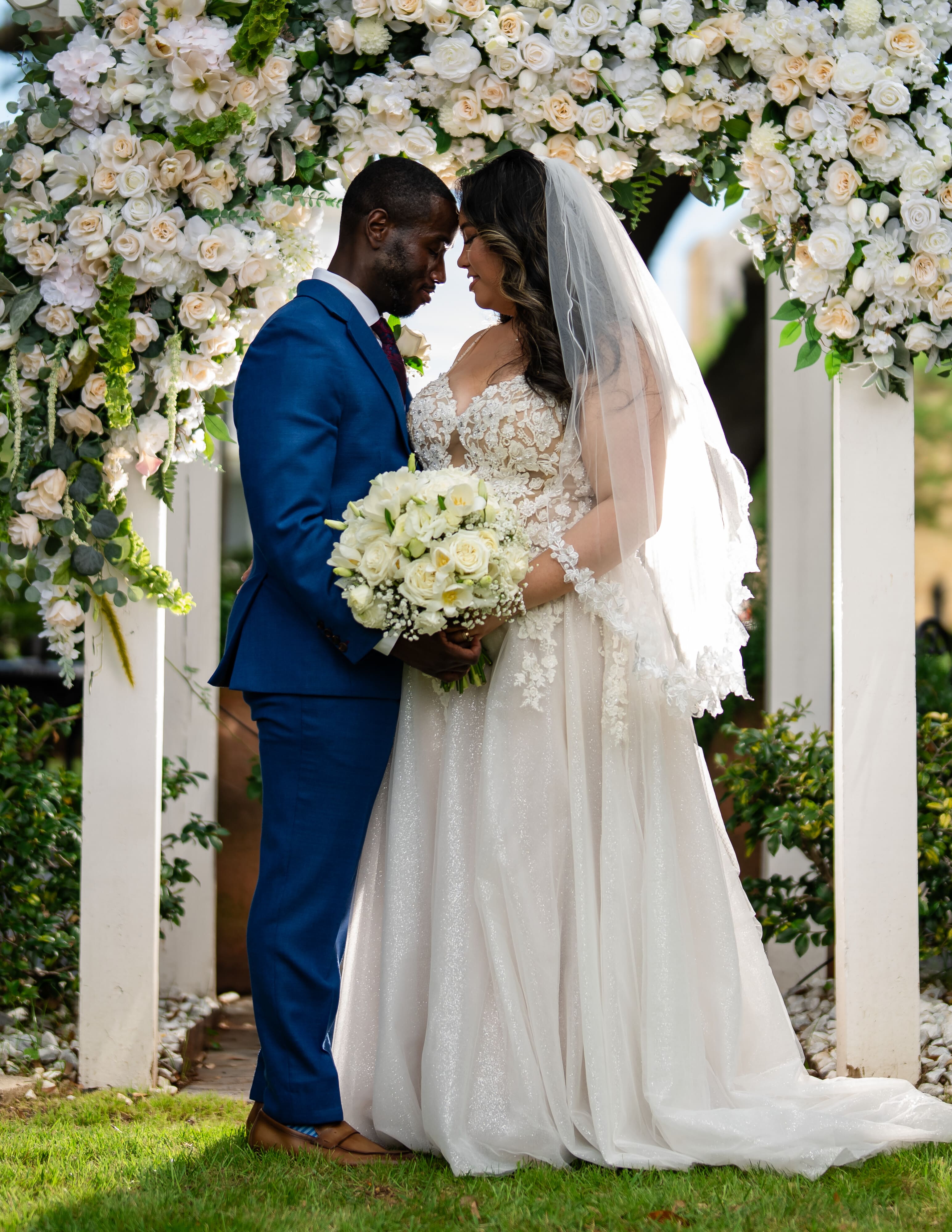 Bride and groom under a floral arch at a Canal Street Inn elopement