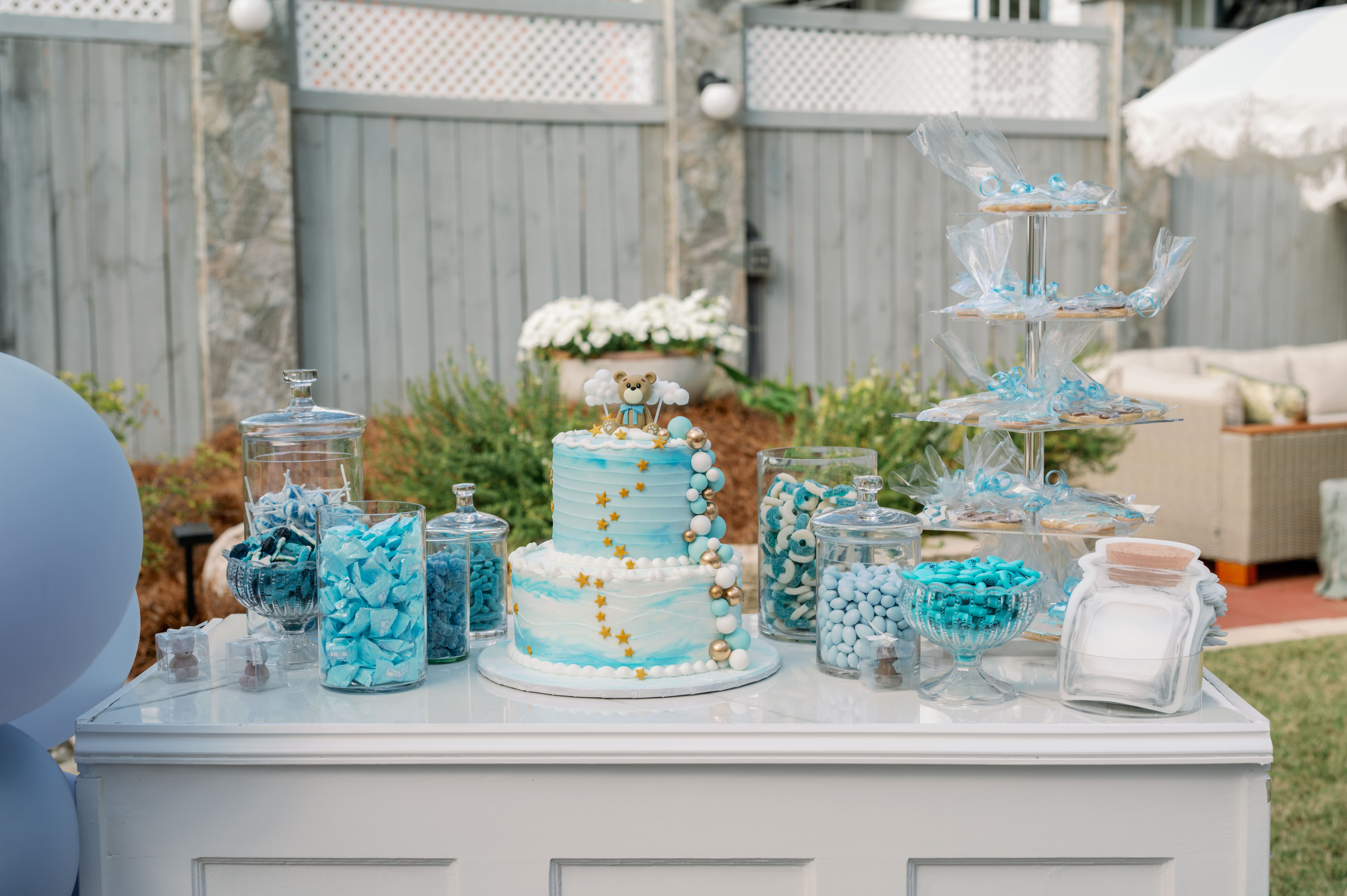 Outdoor garden celebration with dessert table, blue and white cake, and patio seating at Canal Street Inn