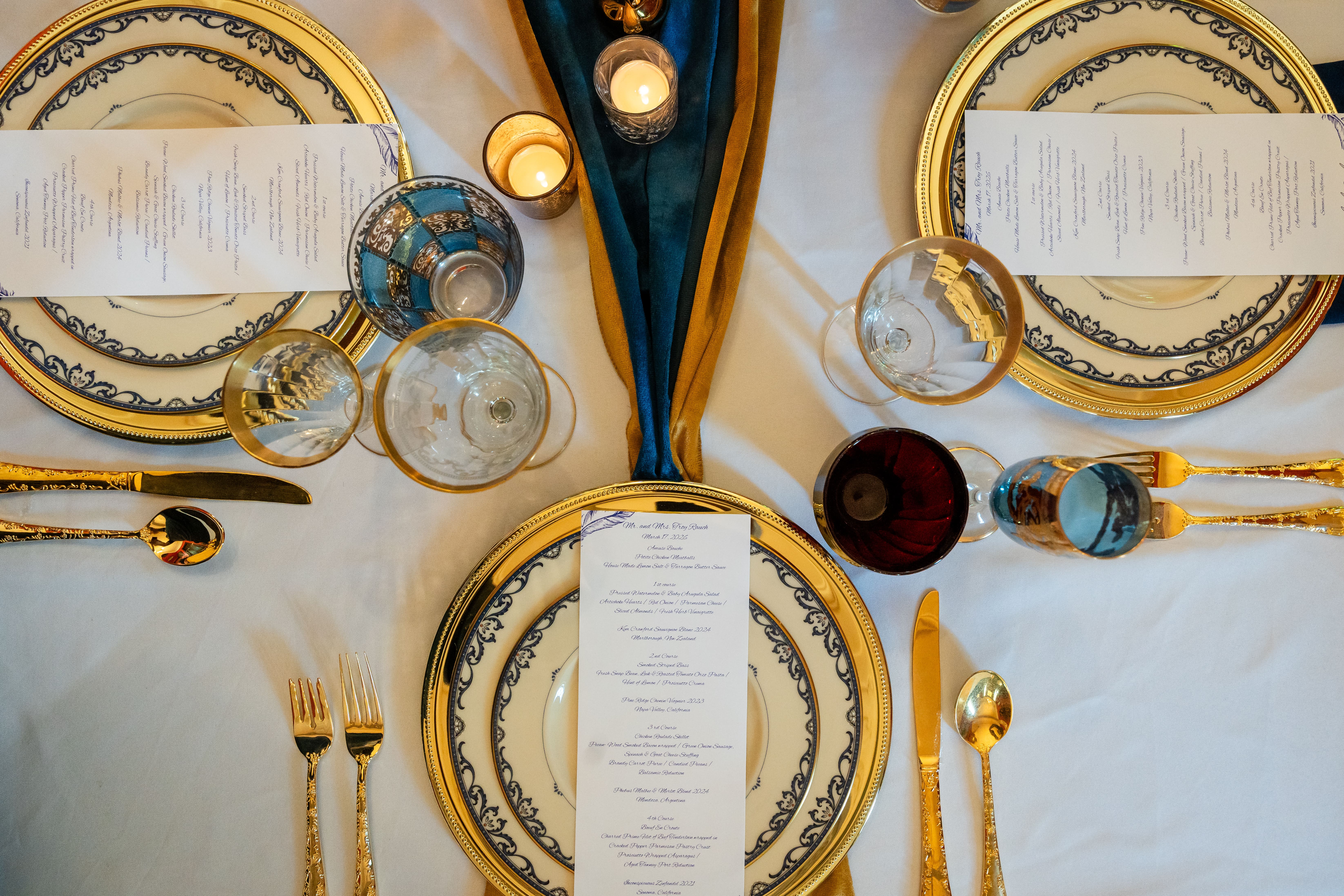 Elegant parlor table setting with gold chargers, navy menus, and candlelight at Canal Street Inn