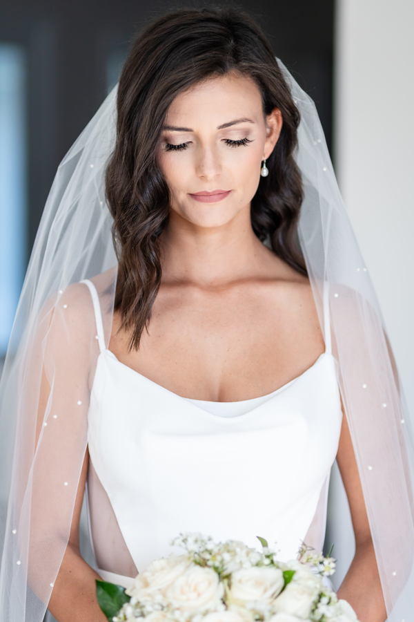 Bride holding a white bouquet before an intimate Canal Street Inn elopement