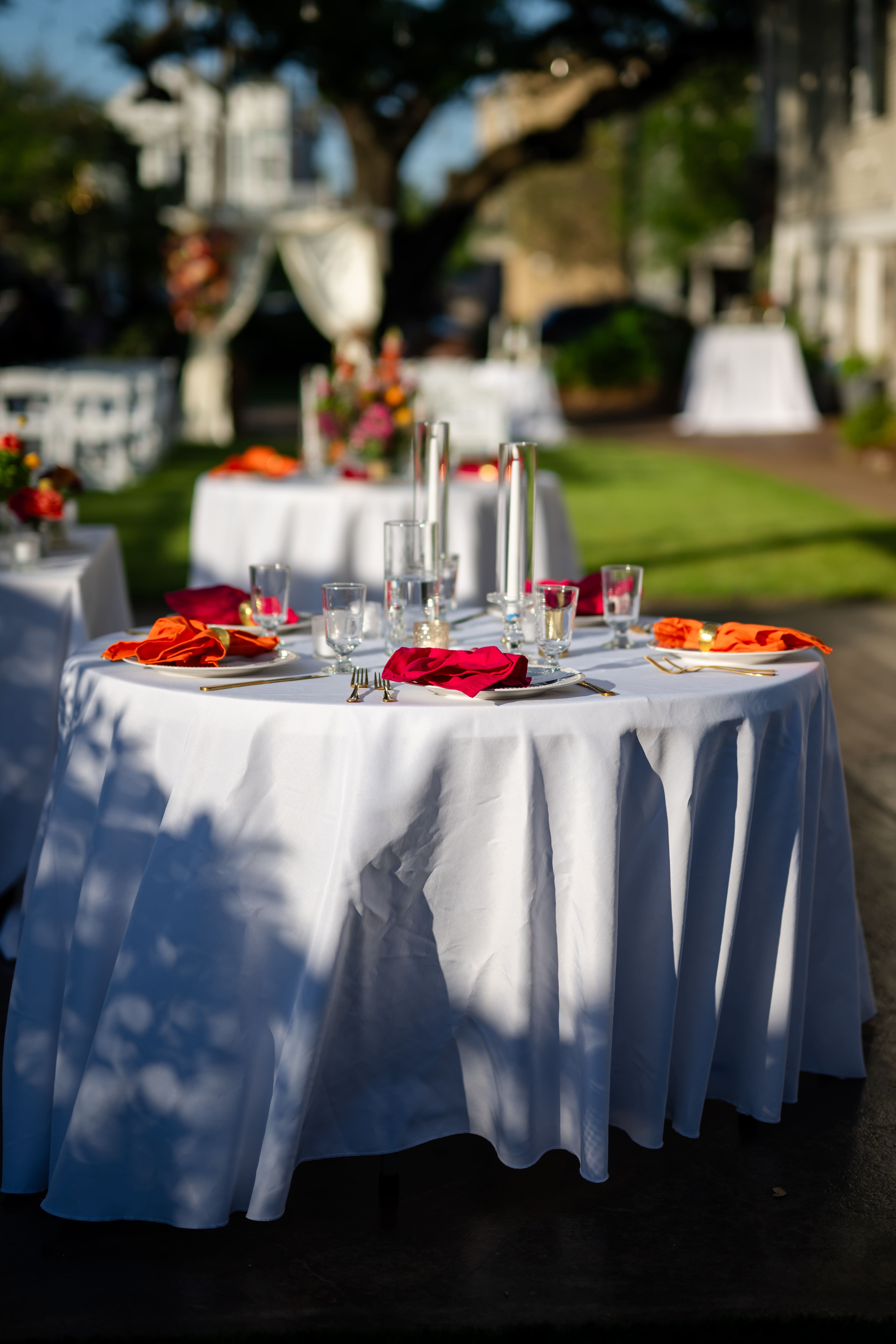 Elegant outdoor wedding reception with round tables set on a lush green lawn at Canal Street Inn, New Orleans